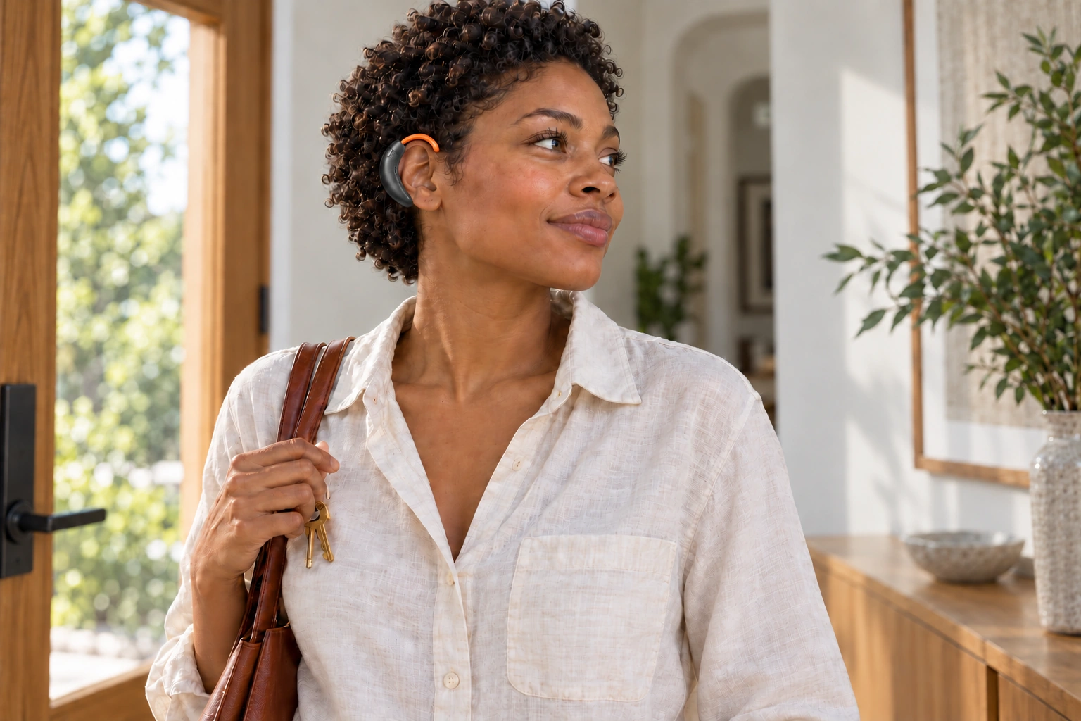 A woman collects her keys in a sunlit apartment.