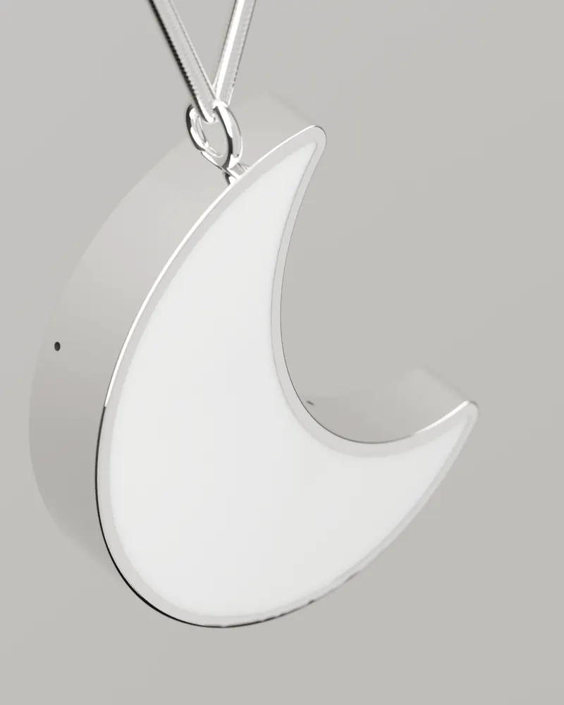 Close on the Moon at an angle: the polished steel side, the stone face and the jump ring at the upper horn.