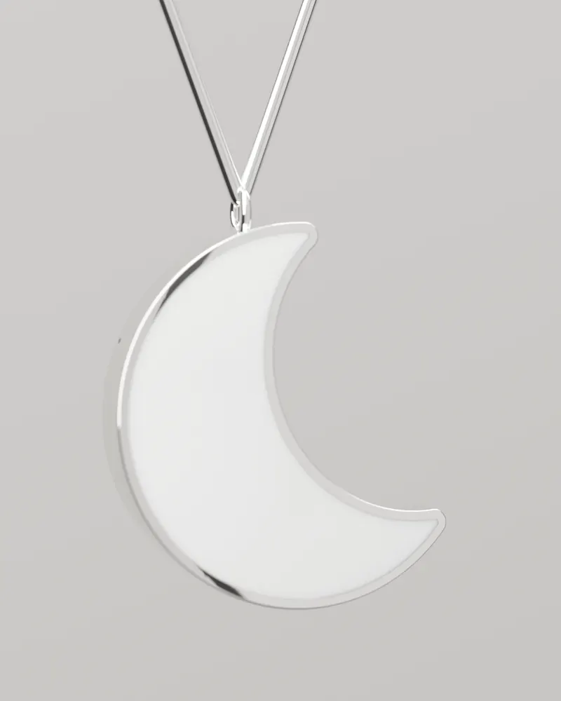 The Moon hanging from its jump ring on a snake chain: a white stone face in a mirror-polished steel rim.